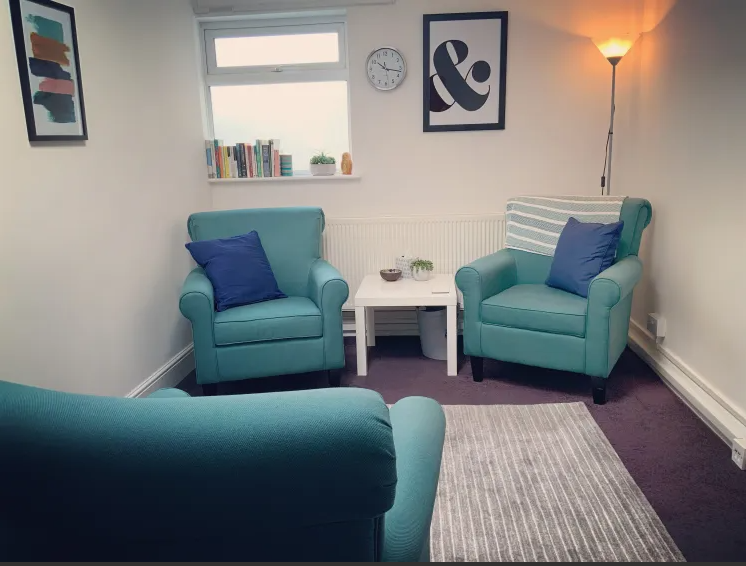A welcoming therapy room with two armchairs and a small table